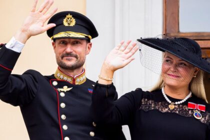 King Haakon VIII and Queen Mette-Marit step onto the balcony as a new reign begins