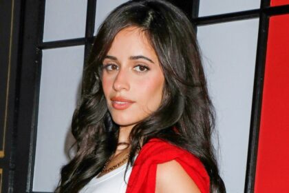 Camila Cabello puts a flirty twist on preppy style in a red knit mini skirt and sky-high white boots