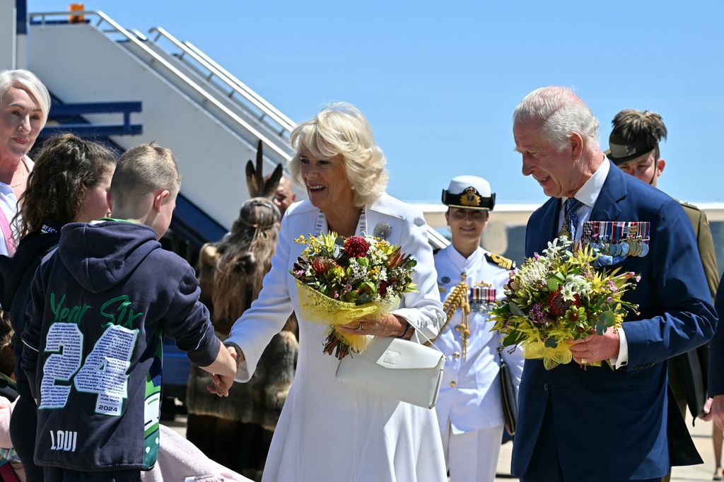 King Charles III and Queen Camilla receive flowers after arriving at Defence Establishment Fairbairn in Canberra 