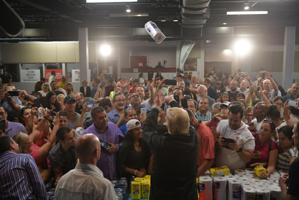 US President Donald Trump takes part in a food and suplly distribution at the Cavalry Chapel in Guaynabo, Puerto Rico on October 3, 2017.Nearly two weeks after Hurricane Maria thrashed through the US territory, much of the islands remains short of food and without access to power or drinking water. / AFP PHOTO / MANDEL NGAN        (Photo credit should read MANDEL NGAN/AFP via Getty Images)