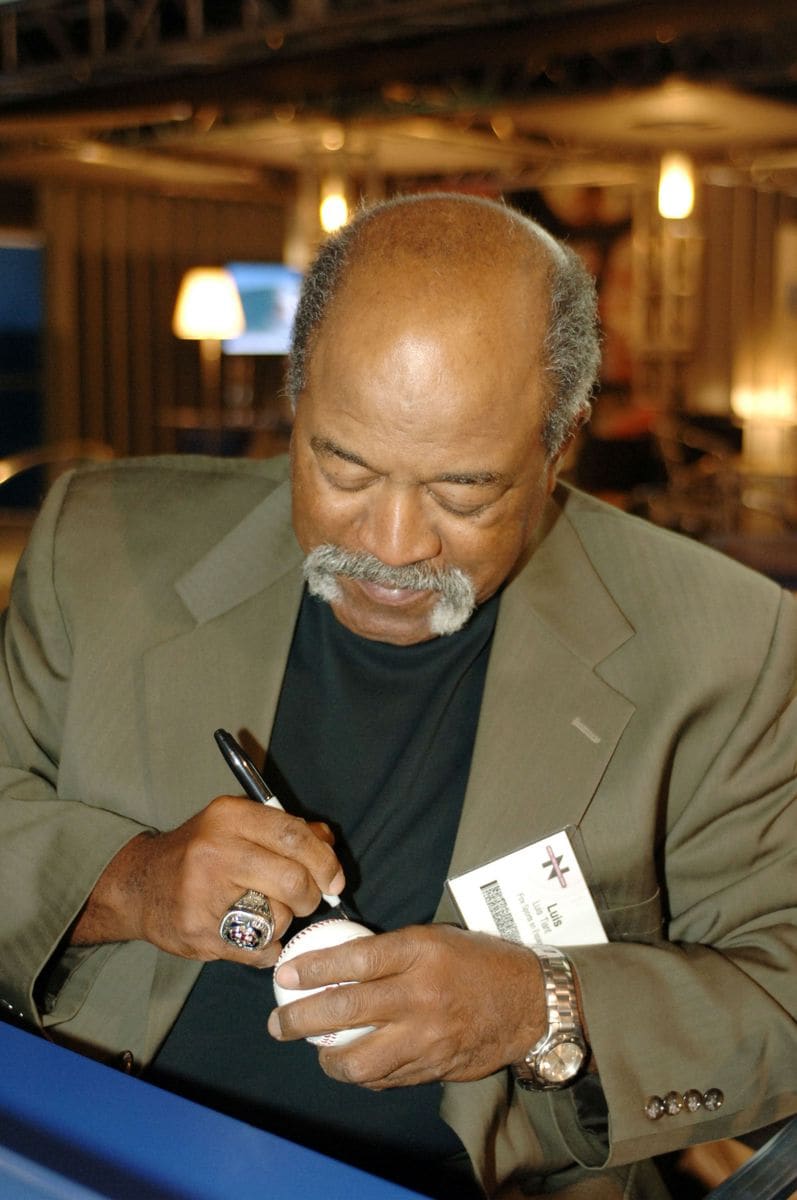 Luis Tiant Signing Autographs for a Happy Fan at the Fox Booth (Photo by Moses Robinson/WireImage for Fox Television Network)