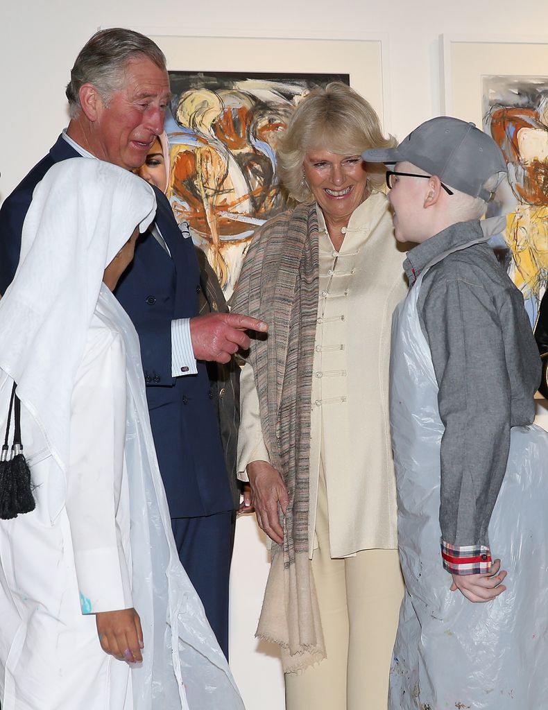 King Charles and Queen Camilla talking to children in Qatar