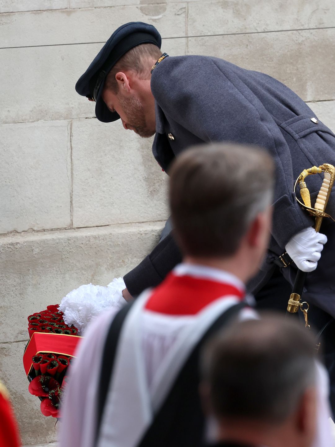 man laying wreath at cenotaph