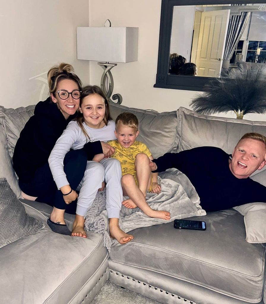 Lucy-Jo Hudson on the sofa with her partner Lewis and two kids