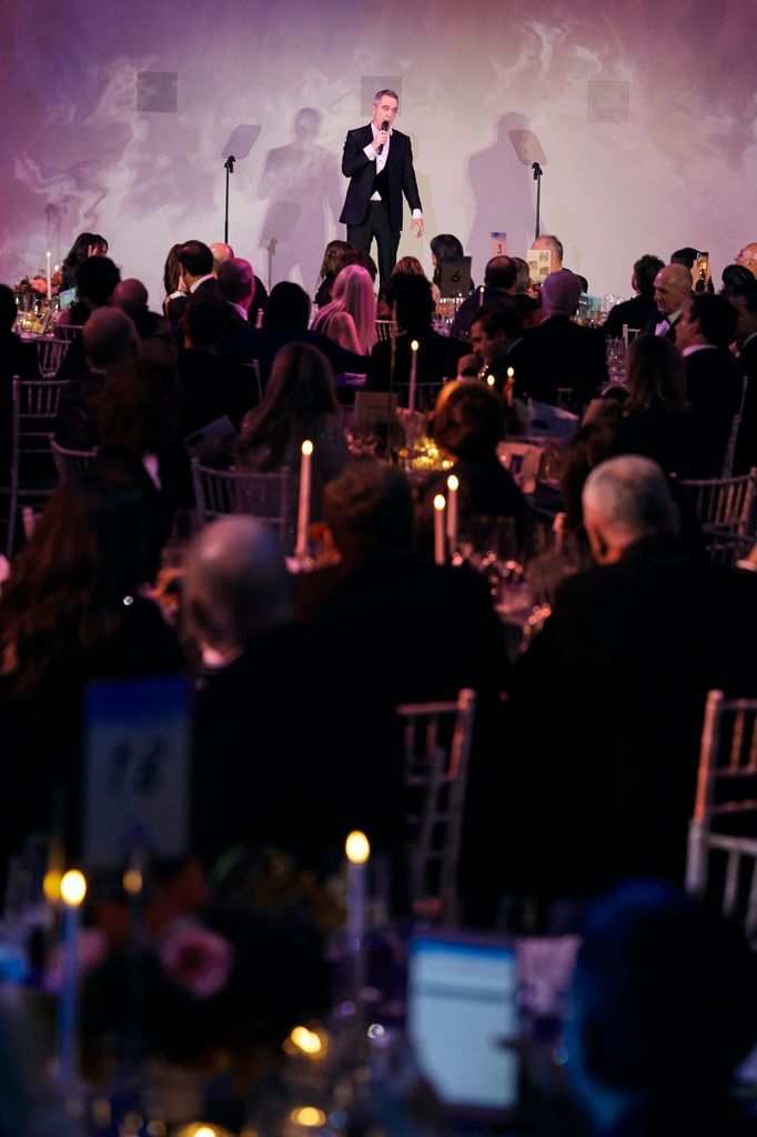 James Nesbitt on stage in front of lots of candlelit tables