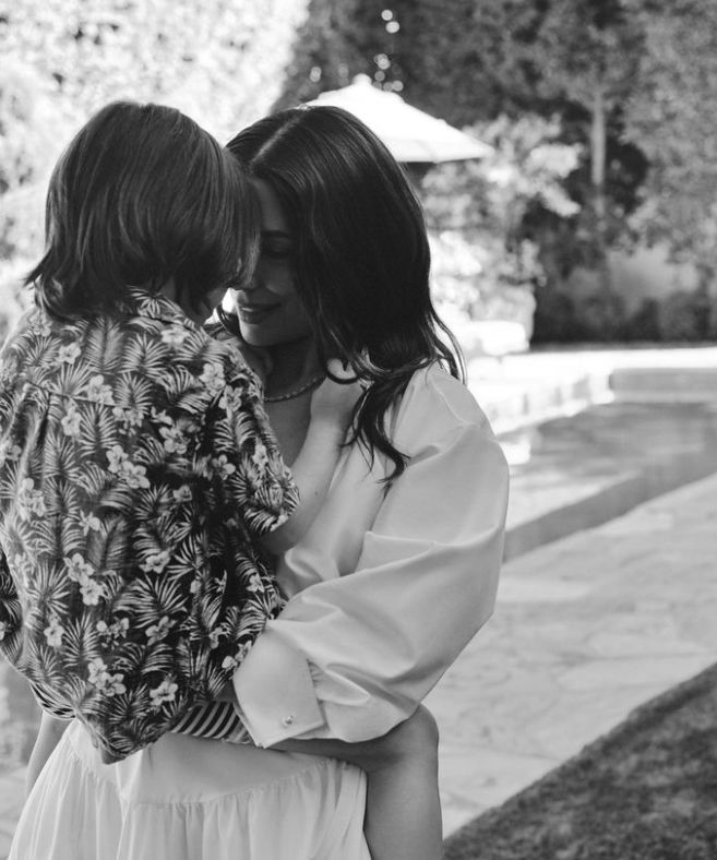 A black-and-white photo of Eva Longoria and her son by a swimming pool