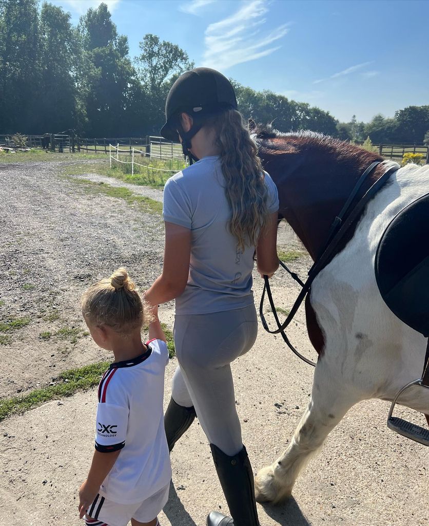 older girl and young boy with horse