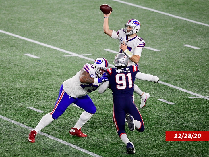 Josh Allen #17 throws a pass as teammate Dion Dawkins #73 of the Buffalo Bills blocks Deatrich Wise #91 of the New England Patriots