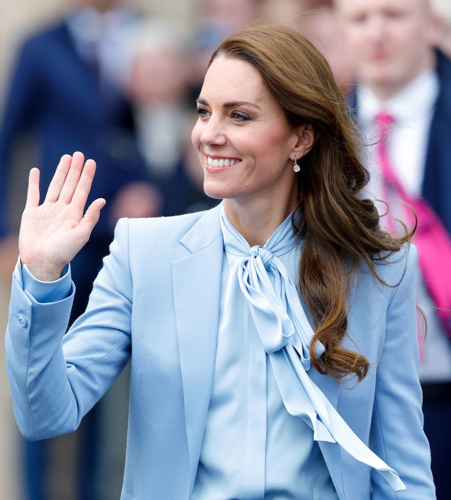 Catherine, Princess of Wales waves in pale blue shirt and coat