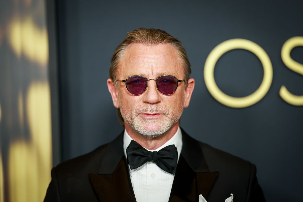 actor posing in suit at awards show 