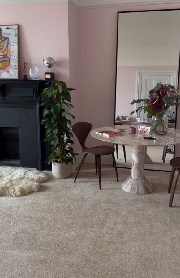 A marble round table in the corner in front of a mirror