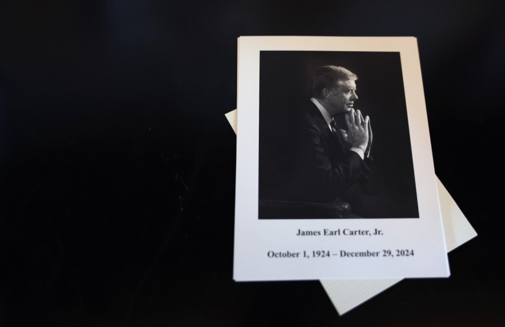 WASHINGTON, DC - JANUARY 08: A picture of U.S. President Jimmy Carter is seen as members of the public sign a condolence book in the U.S. Capitol Visitor Center on January 08, 2025 in Washington, DC. Carter's body will lie in state in the Capitol Rotunda until a funeral service at the National Cathedral in Washington on January 9. Carter, the 39th President of the United States, died at the age of 100 on December 29, 2024 at his home in Plains, Georgia. (Photo by Kevin Dietsch/Getty Images)