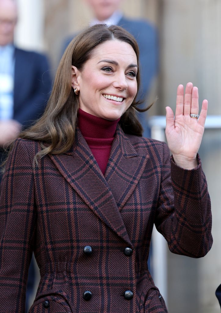 Catherine waving in tartan brown coat