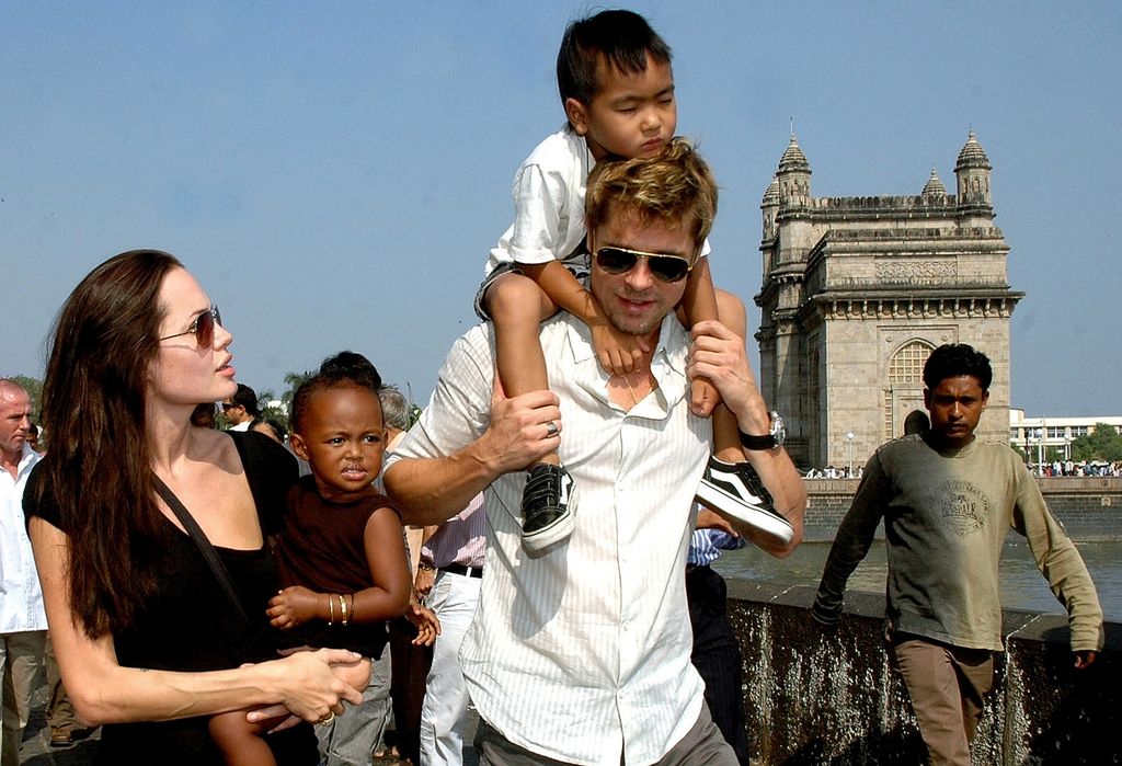 Angelina Jolie (L) holds daughter Zahara as husband and actor Brad Pitt (C) carries son Maddox in 2006