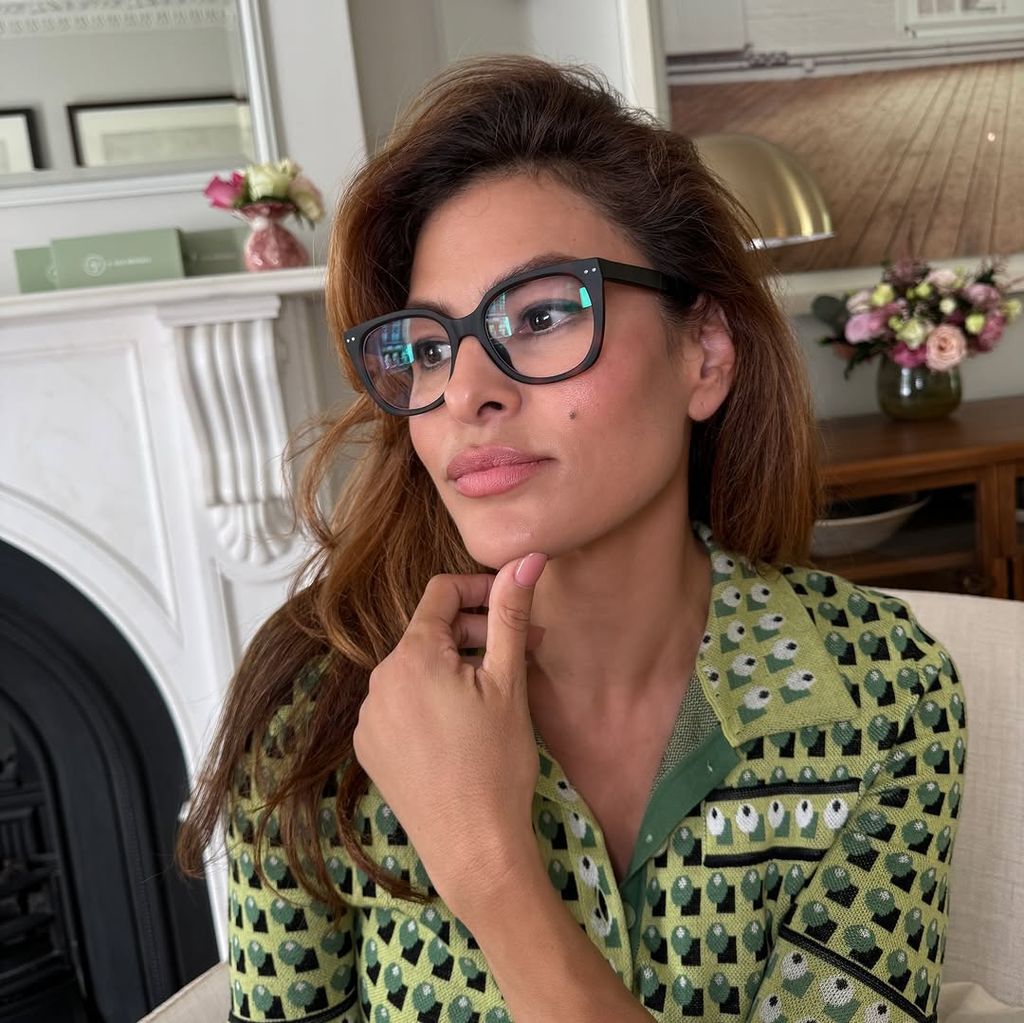 Eva Mendes in a green top while sitting on an armchair in her living room in London