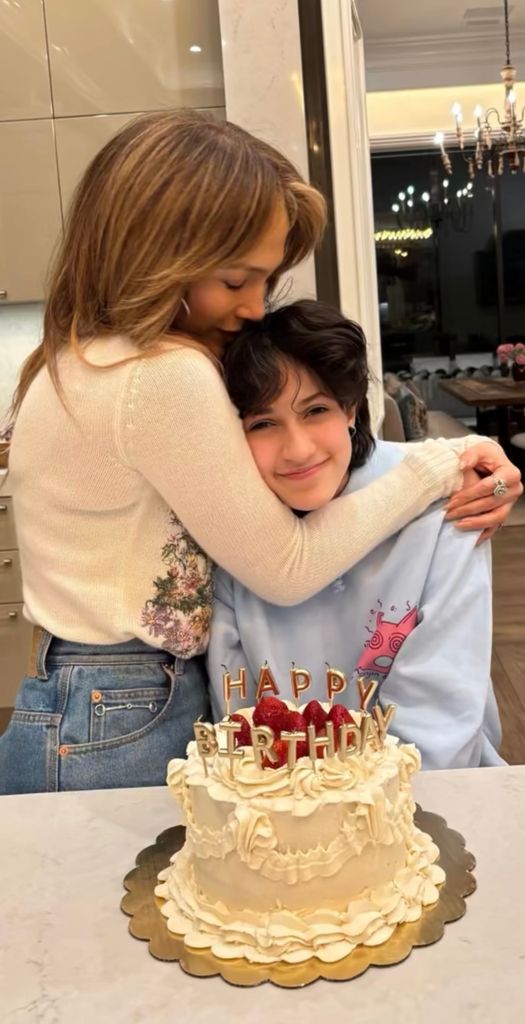 Jennifer Lopez hugs child Emme with their birthday cake on their 17th birthday in a photo shared on Instagram