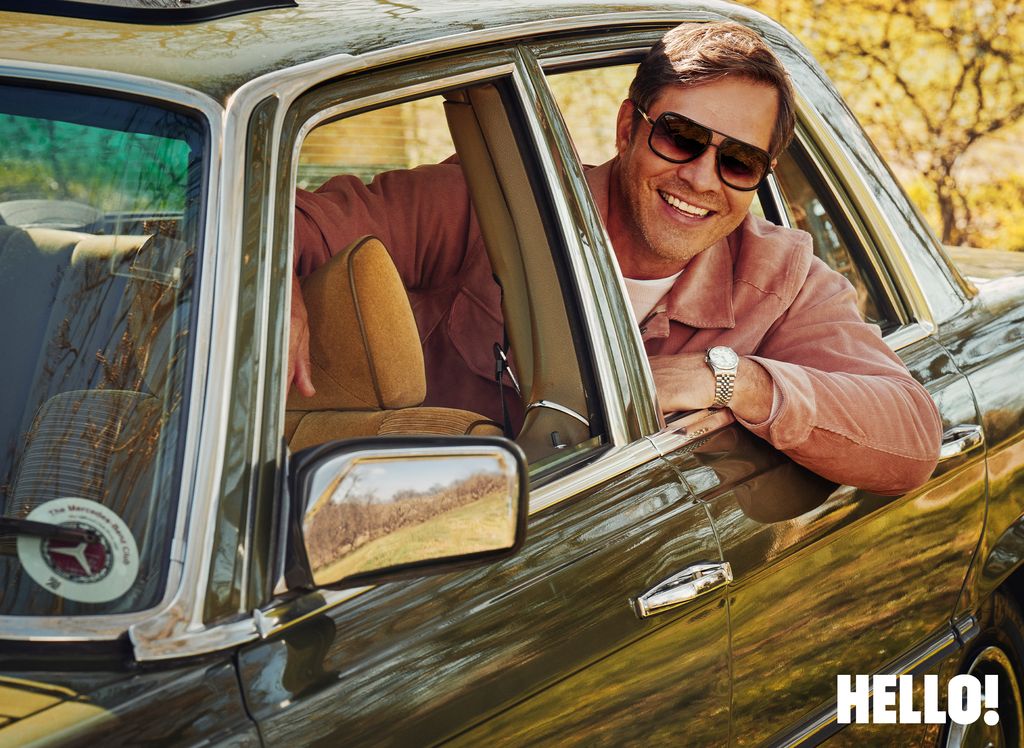 A man smiling from inside his car