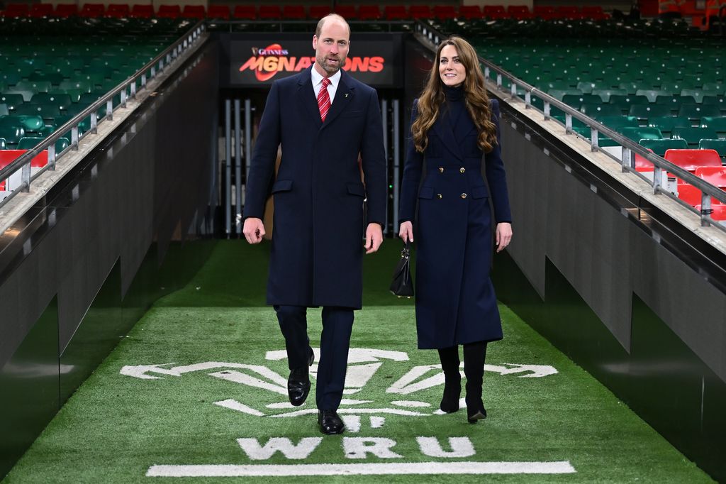 Prince William and Kate Middleton walking through a stadium