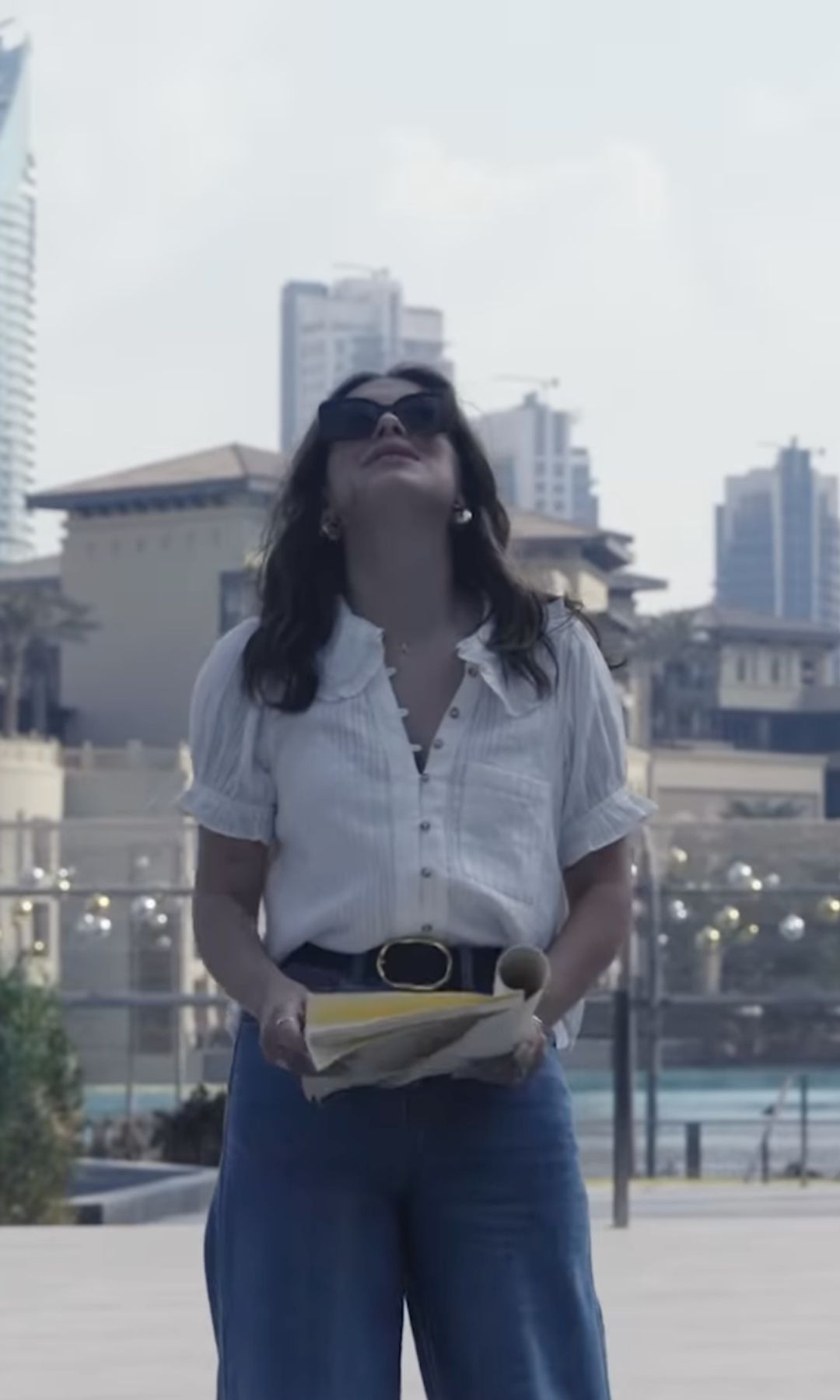 Millie holds a script and looks up to the sky during a break in filming her short Dubai film