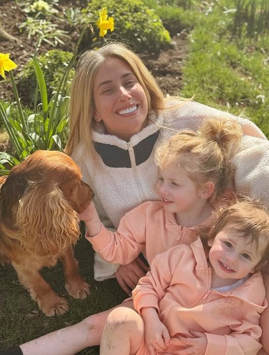 Stacey Solomon in a garden with her dog and two daughters