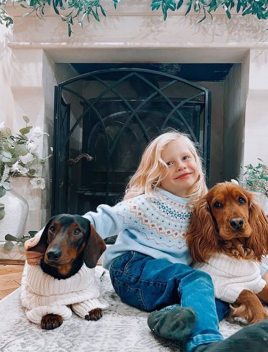 A young girl with two girls in Christmas jumpers