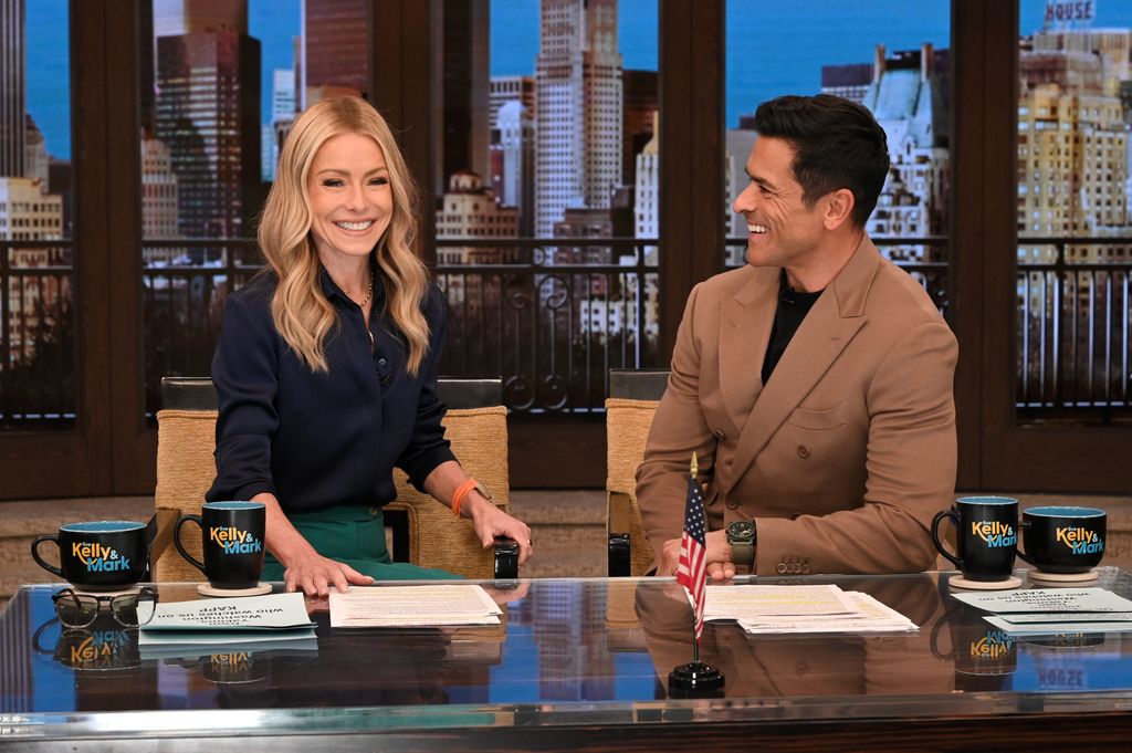LIVE WITH KELLY AND MARK - Kelly Ripa and Mark Consuelos captured laughing together at their hosting desk