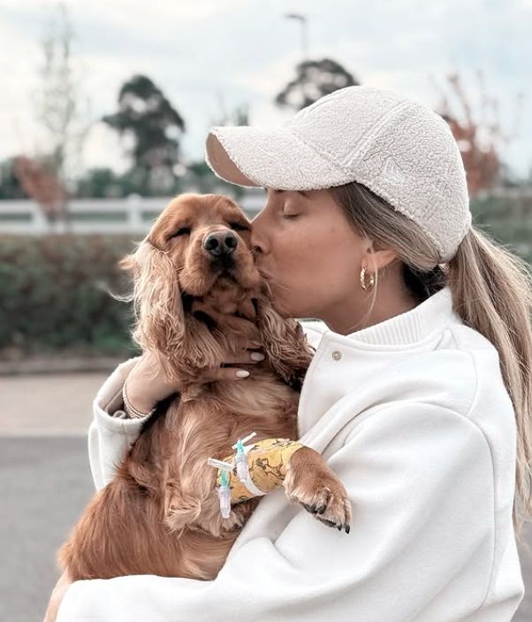 Stacey Solomon kissing a dog on the side of its face