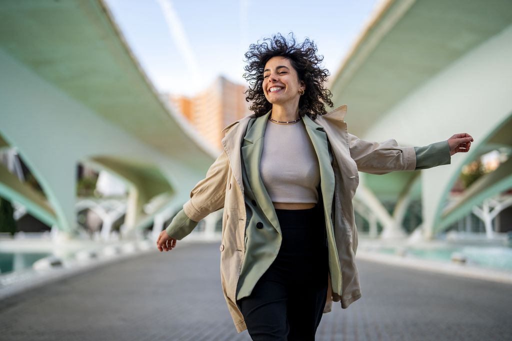 Smiling woman jumping high after successful job interview
