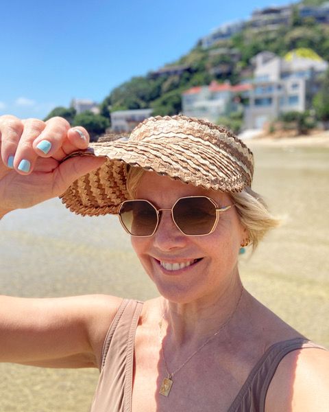 Woman on the beach in a sun hat smiling