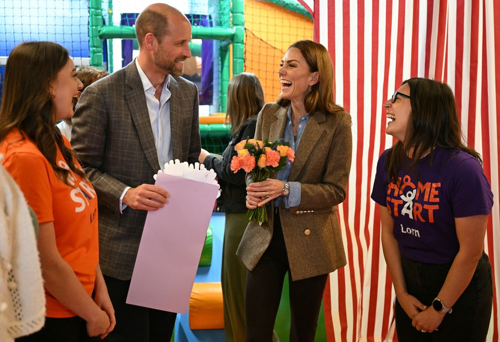 Kate Middleton laughing and holding flowers