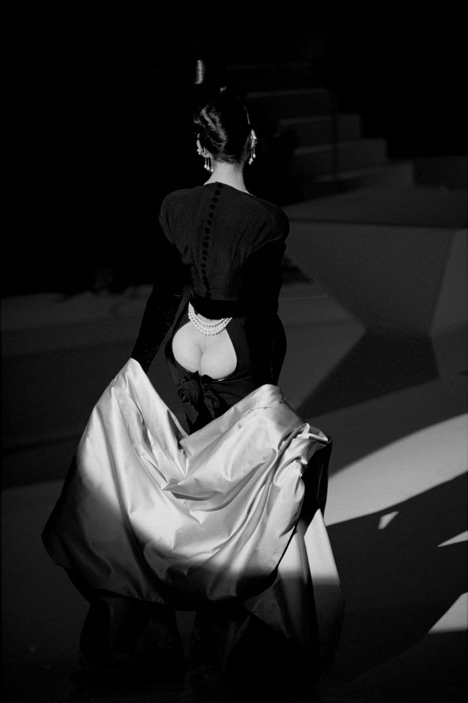 Dropping a cape of organza silk, a model wears Thierry Mugler's black evening sheath with jet velvet sleeves in his fall/winter 1995 ready-to-wear collection, presented in the Paris Cirque d'Hiver 