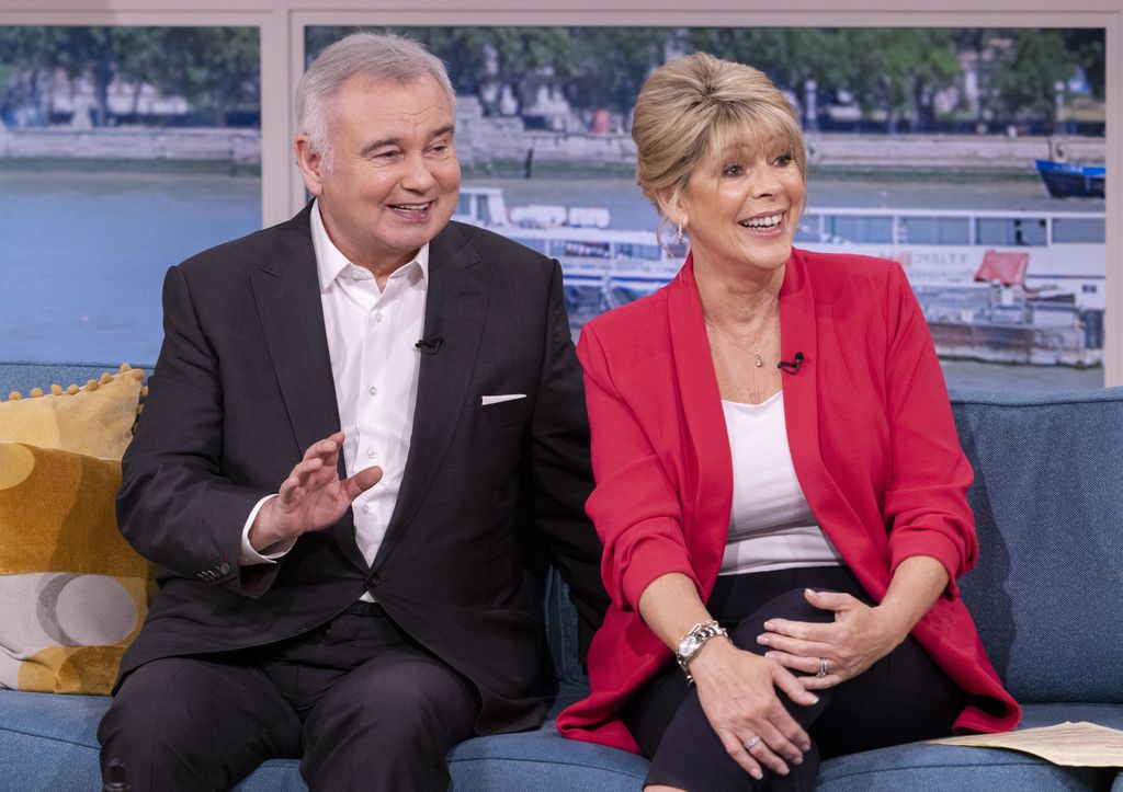 Eamonn Holmes in black suit and Ruth Langsford in red blazer on set of This Morning