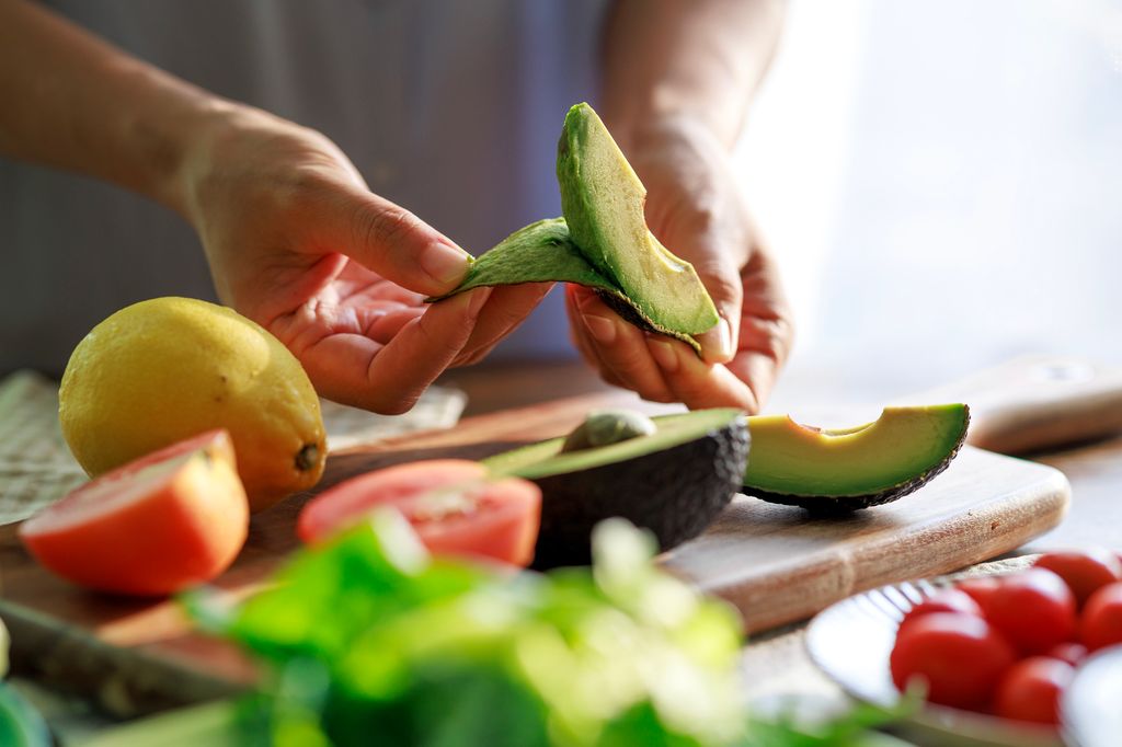 Stock image of man peeling avocado