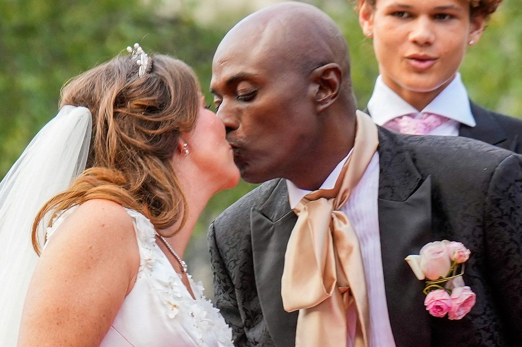 Princess Martha Louise of Norway and Durek Verrett kiss as they arrive at their wedding party at Hotel Union in Geiranger