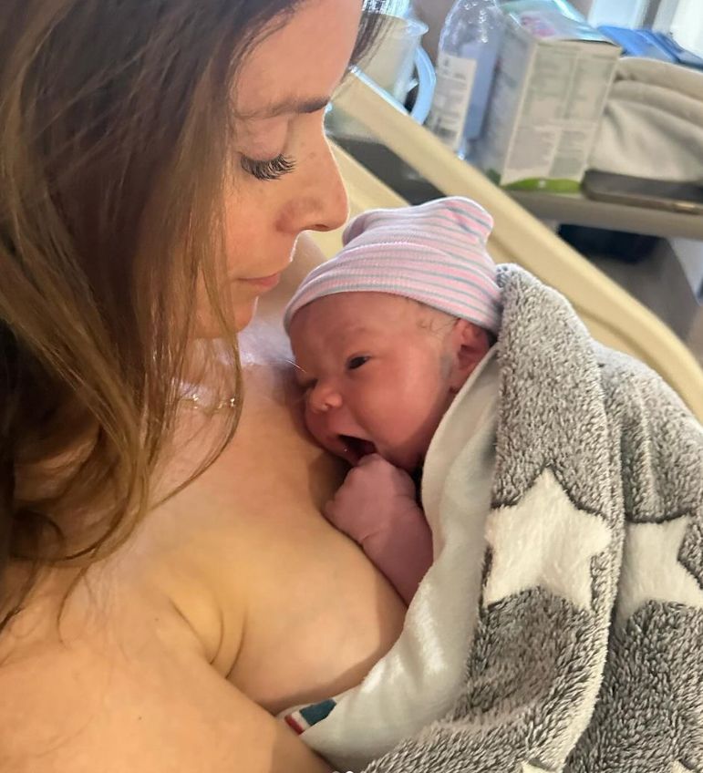 Tana Ramsay with a baby on her chest
