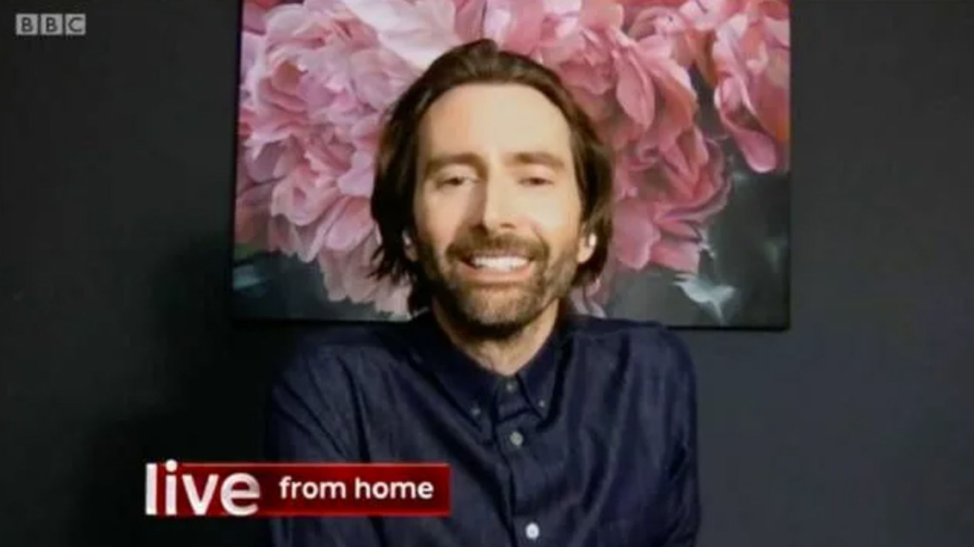David Tennant sitting in front of a painting