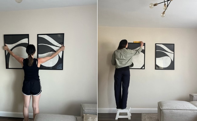 woman hanging pictures on wall 
