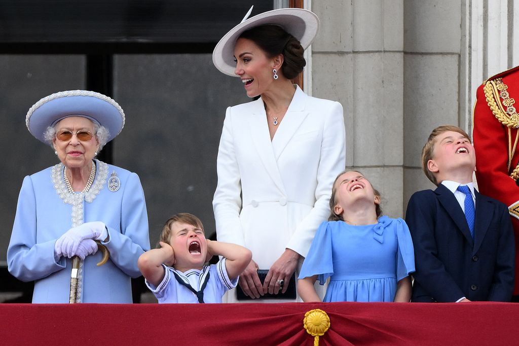 Britain's Prince Louis of Cambridge (2L) holds his ears as he stands next to Britain's Queen Elizabeth II (L), his m mother Britain's Catherine, Duchess of Cambridge (C), Britain's Princess Charlotte of Cambridge (2R)and Britain's Prince George of Cambridge to watch a special flypast