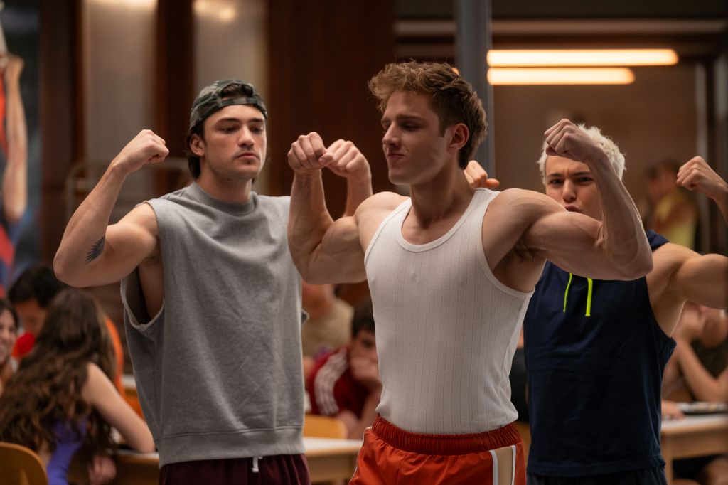 three young male athletes flexing muscles 