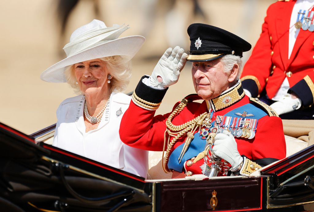 Queen Camilla in white and King Charles in uniform
