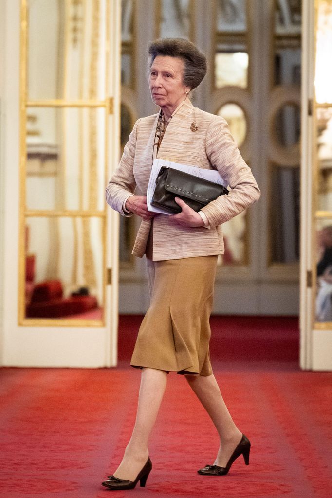 Princess Anne walking with a speech and black clutch bag