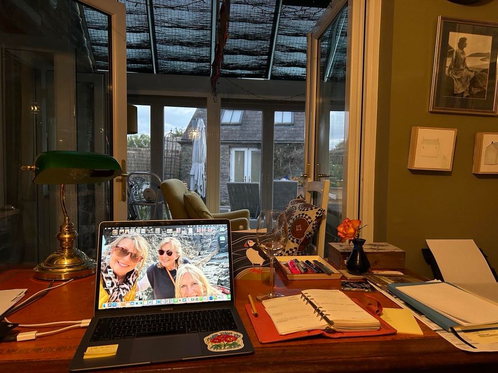 fern's office with busy desk looking out to garden