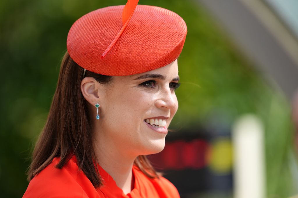 Princess Eugenie side on smiling in red hat