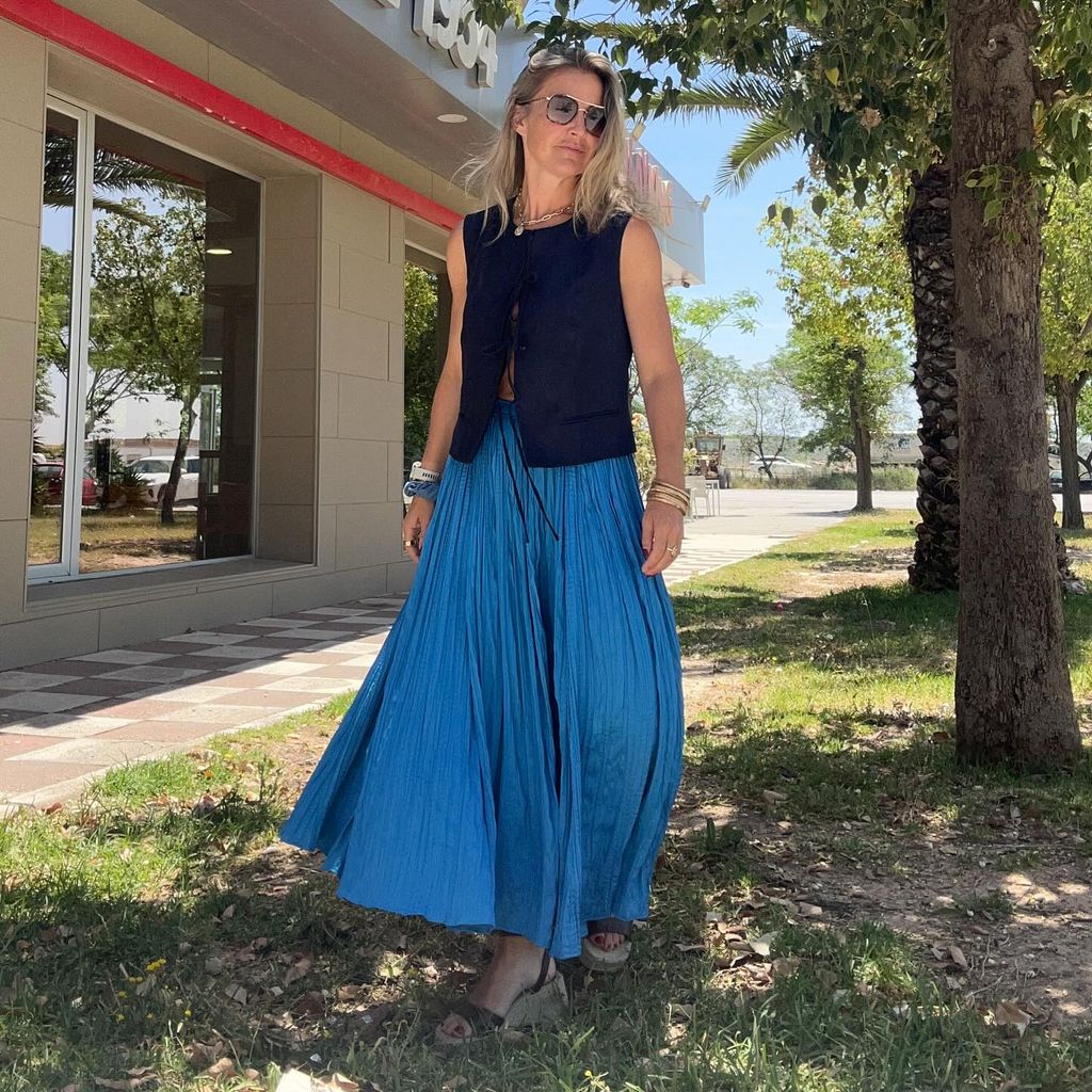 Helen in navy top and blue skirt outside