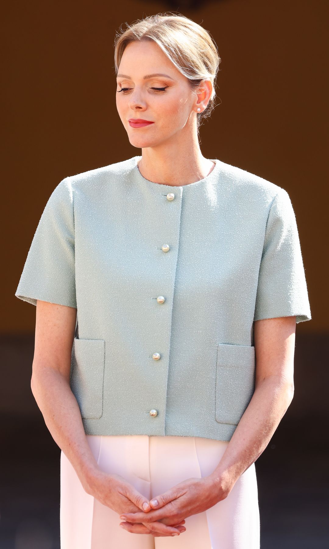 Princess Charlene in a mint jacket and tan trousers