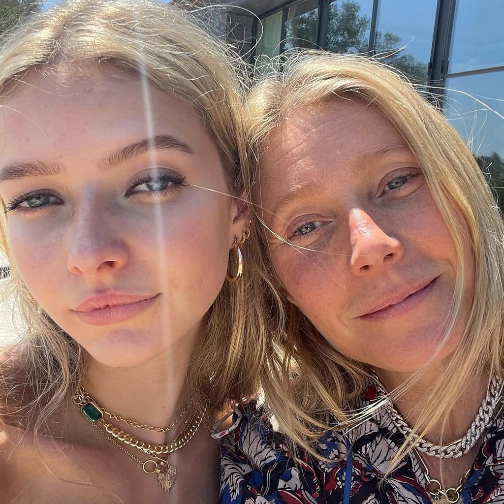 Gwyneth Patrow and Apple with their heads together posing 