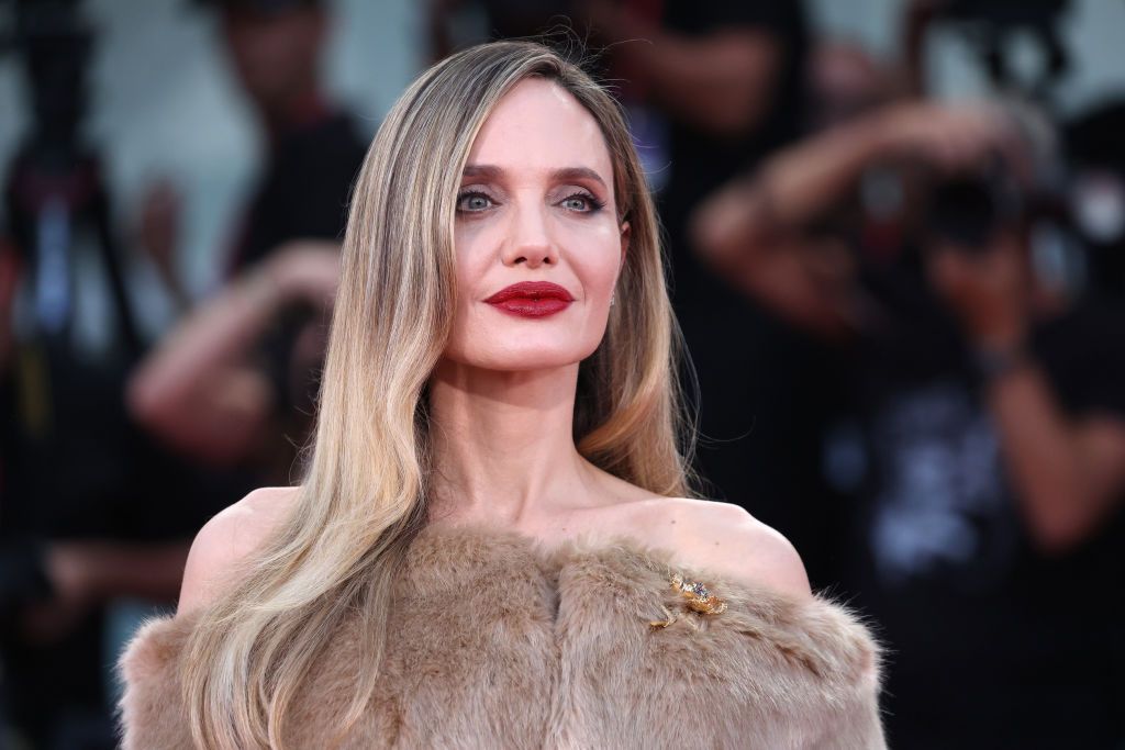 angelina jolie with blonde hair and a red matte lip