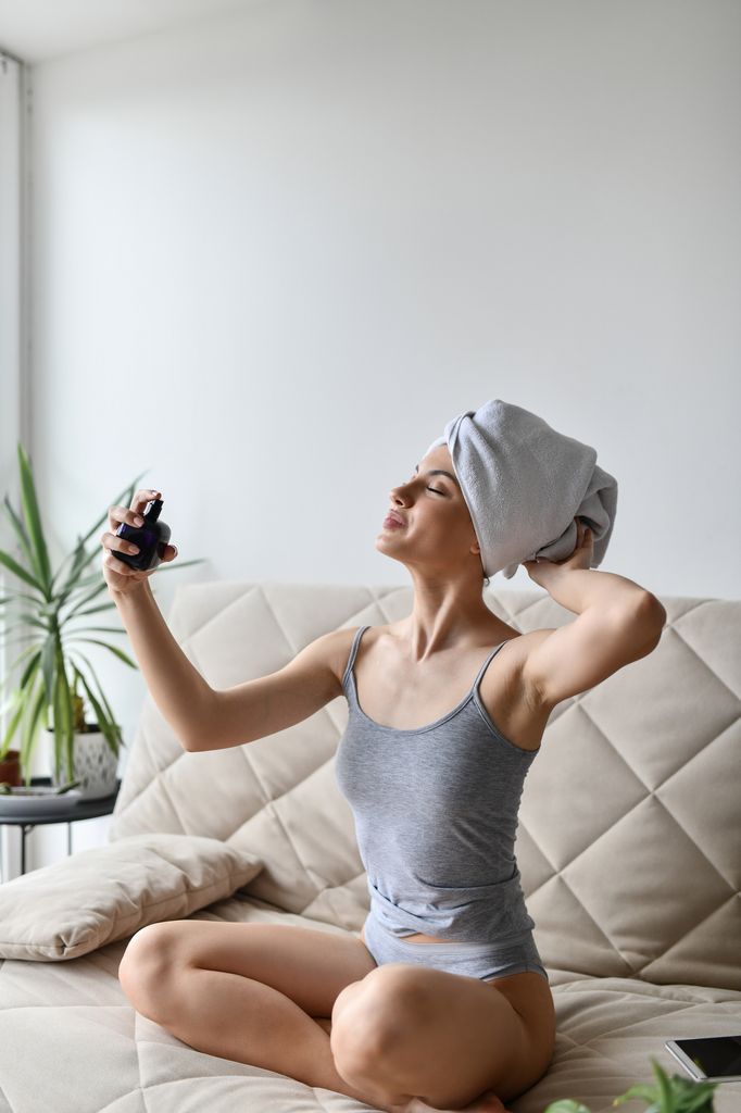 Beautiful Female Spraying Perfume After Taking A Shower