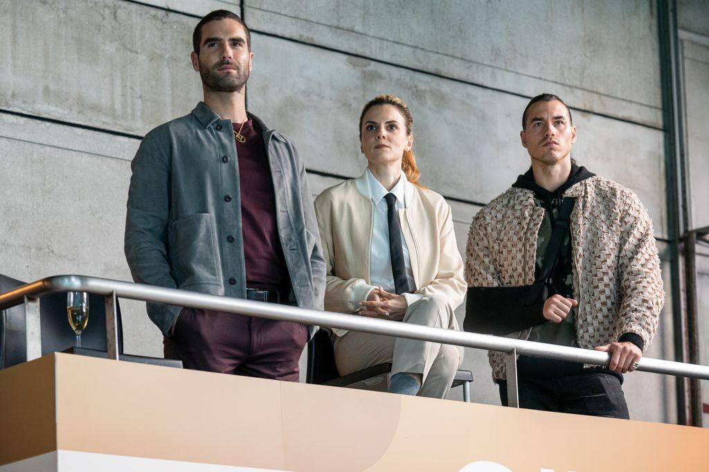 two men and a woman watching from a viewing platform