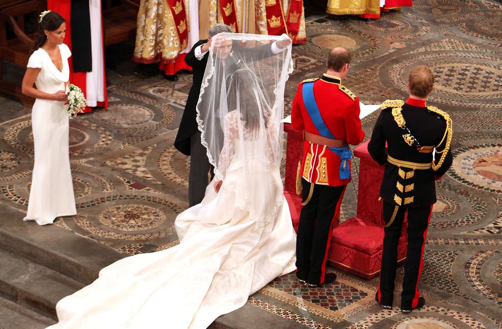 Father of the bride Michael Middleton lifts the bridal veil from his daughter Catherine Middleton's face